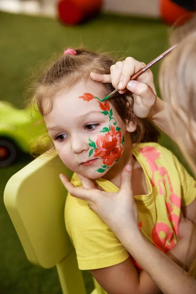 The animator draws a children's makeup drawing on the face of a child — Stock Photo, Image