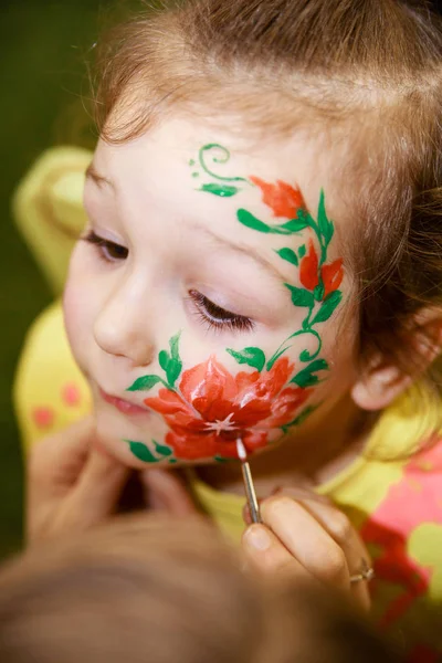 Animatör yüzünde bir çocuk çizim bir çocuk makyaj çizer