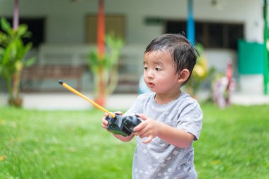 Küçük Asyalı çocuk (han kontrol bir radyo kontrol holding