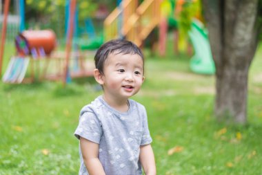 Küçük Asyalı çocuk oyun ve Bahçesi altında gülüp