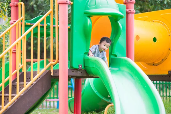 Liten asiatisk unge spelar slide på lekplatsen — Stockfoto