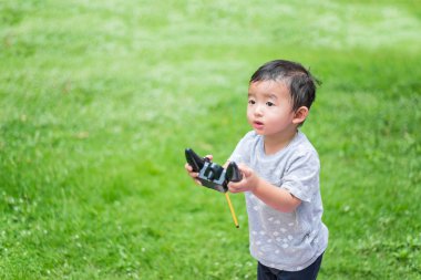 Küçük Asyalı çocuk (han kontrol bir radyo kontrol holding