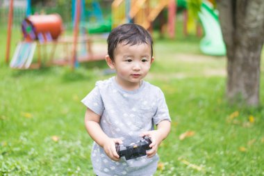 Küçük Asyalı çocuk (han kontrol bir radyo kontrol holding