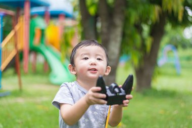 Küçük Asyalı çocuk (han kontrol bir radyo kontrol holding