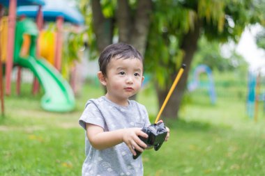 Küçük Asyalı çocuk (han kontrol bir radyo kontrol holding