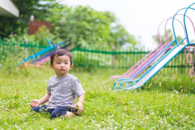 Küçük Asyalı çocuk oyun ve Bahçesi altında gülüp