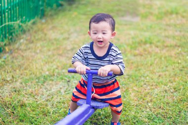 Asyalı Çocuk Bahçesi güneş ışığı altında tahterevalli tahtaya sürme, 