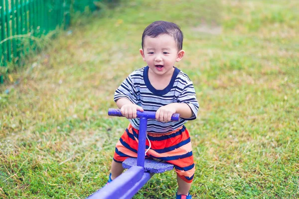 Asyalı Çocuk Bahçesi güneş ışığı altında tahterevalli tahtaya sürme, 