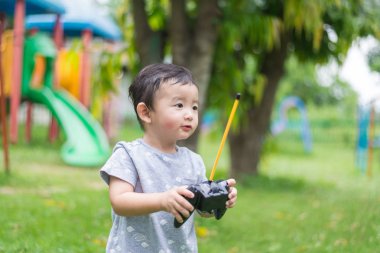 Küçük Asyalı çocuk (han kontrol bir radyo kontrol holding