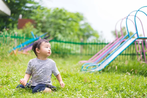 Piccolo bambino asiatico che gioca e sorride al parco giochi sotto il — Foto Stock