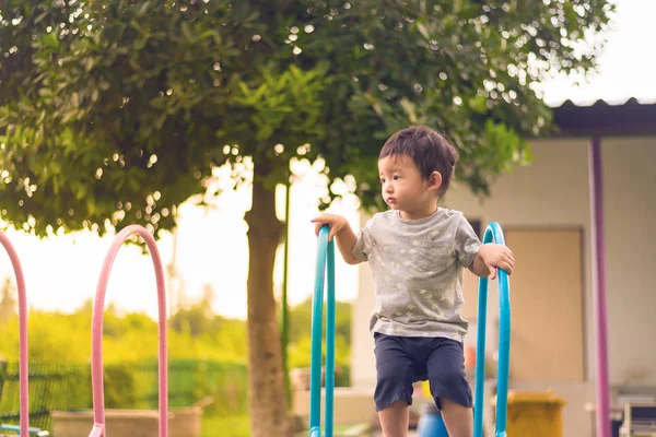 Küçük Asyalı çocuk slayt parkta oynarken