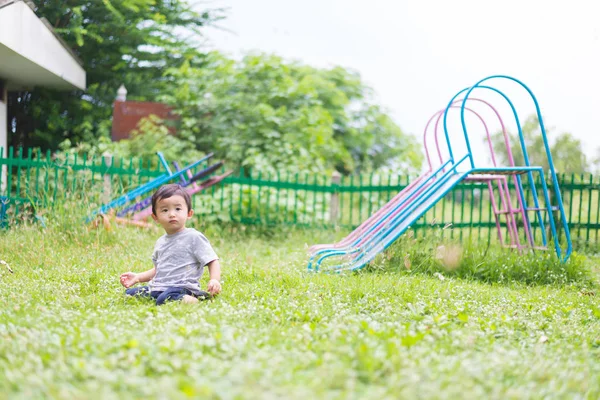 Kleine Aziatische jongen spelen en lachend op de speelplaats onder de — Stockfoto