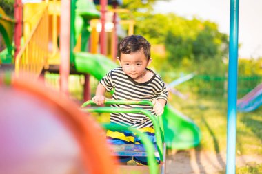 Küçük Asyalı çocuk oyun ve Bahçesi altında gülüp