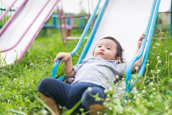 Pequeño asiático niño jugando diapositiva en el patio de recreo — Foto de Stock