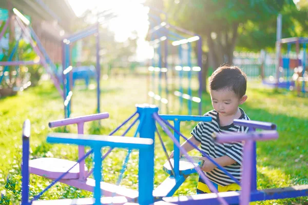 Triste niño asiático en el patio de recreo bajo la luz del sol en suma — Foto de Stock