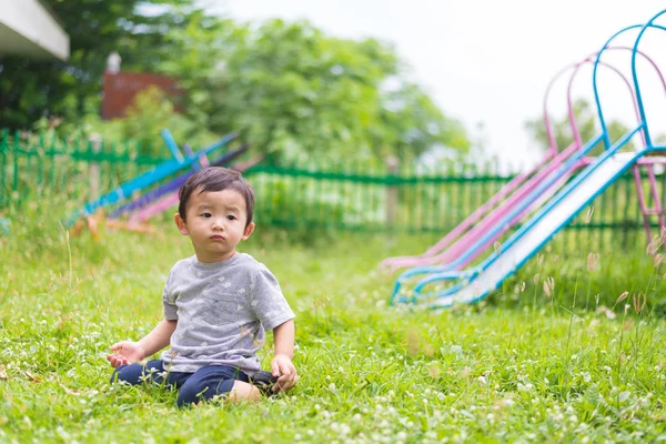 Pequeno garoto asiático brincando e sorrindo no playground sob o — Fotografia de Stock