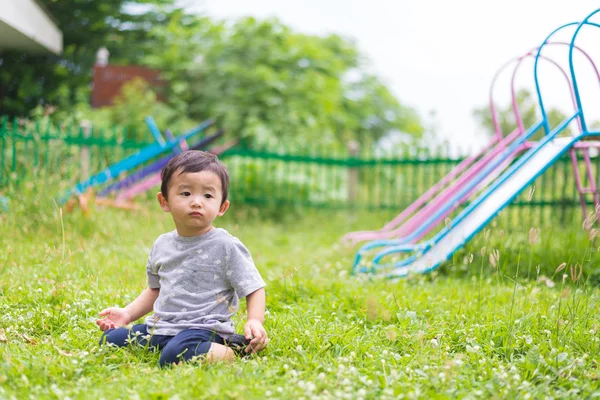 Little Asian kid playing and smiling at the playground under the — Stock Photo, Image