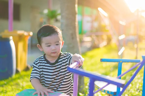 Sad little Asian kid at the playground under the sunlight in sum — Stock Photo, Image