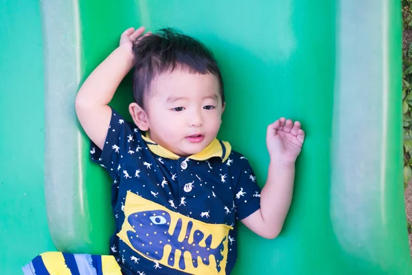 Pequeño asiático niño jugando diapositiva en el patio de recreo . — Foto de Stock