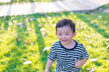 Küçük Asyalı çocuk oyun ve Bahçesi altında gülüp