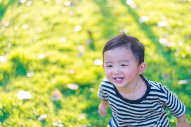 Küçük Asyalı çocuk oyun ve Bahçesi altında gülüp