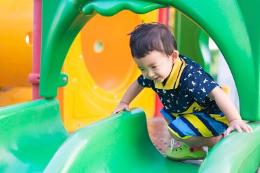 Küçük Asyalı Çocuk Bahçesi sunli altında slayt oynayan