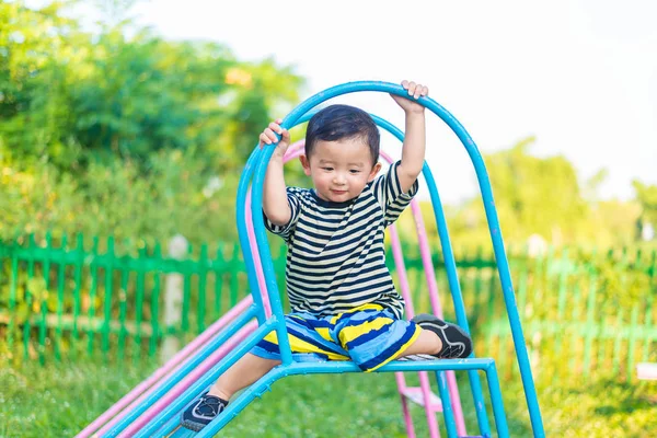 Üzgün küçük Asyalı Çocuk Bahçesi d, slayt üzerinde oturmak