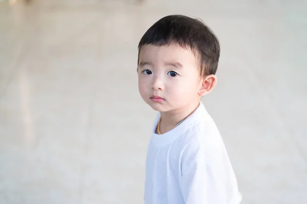 Närbild lilla asiatiska pojke tittar upp någonstans och tänker med — Stockfoto