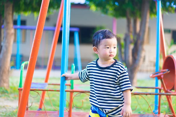 Triste niño asiático en el patio de recreo bajo la luz del sol en suma — Foto de Stock