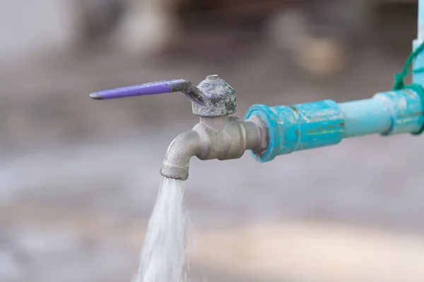 Wassertropfen aus altem Chromhahn und Wasserleitung. — Stockfoto