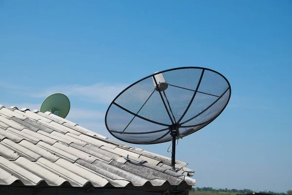 青い空と屋根の上の衛星放送受信アンテナ. — ストック写真