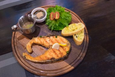 Beyaz tabak içinde taze salata ızgara somon steak.