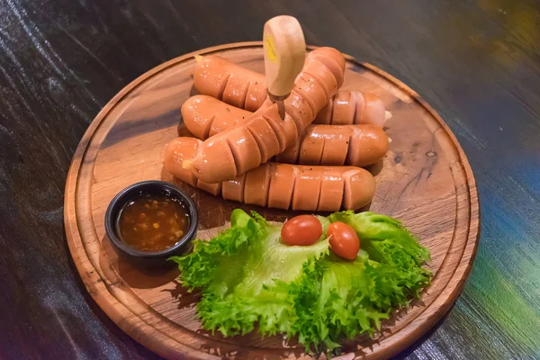 Fried sausages with vegetable in wood plate. On the wooden table — Stock Photo, Image