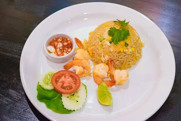 Arroz frito de camarones en plato blanco sobre mesa de madera oscura . —  Fotos de Stock