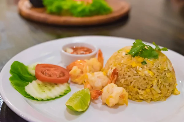 Arroz frito de camarão em prato branco na mesa de madeira escura . — Fotografia de Stock