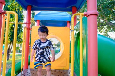 Üzgün küçük Asyalı Çocuk Bahçesi gün zaman, slayt üzerinde