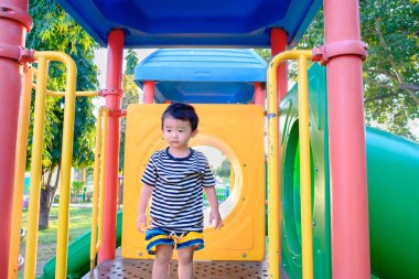 Üzgün küçük Asyalı Çocuk Bahçesi gün zaman, slayt üzerinde