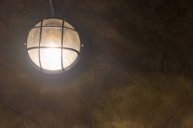 Koyu arka plan üzerinde parlayan tungsten Duvar lambası.