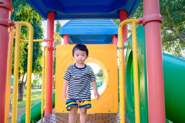 Üzgün küçük Asyalı Çocuk Bahçesi gün zaman, slayt üzerinde