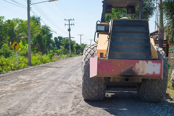 Veicolo da costruzione stradale sulla strada rurale accidentata . — Foto Stock