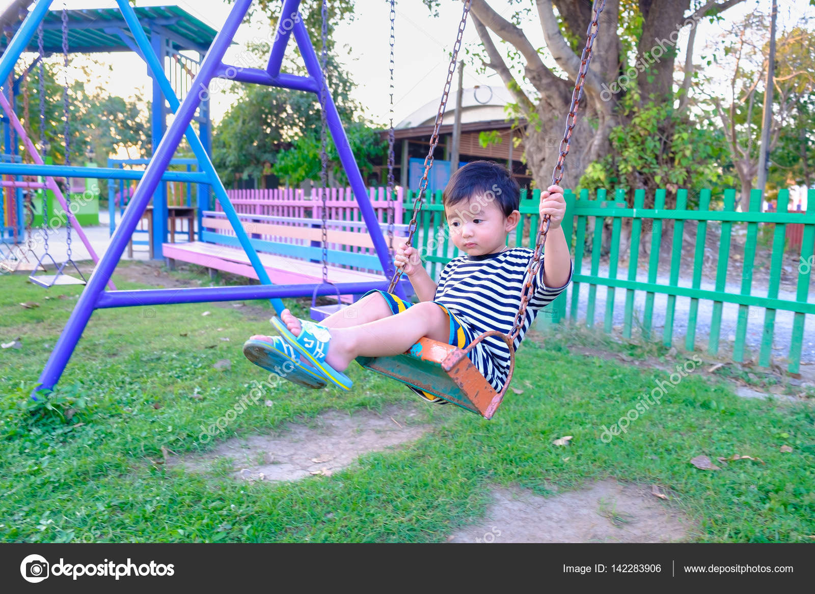 Sad Asian Boy Play A Iron Swinging At The Playground Under