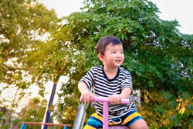 Asyalı Çocuk Bahçesi güneş ışığı altında tahterevalli tahtaya sürme,