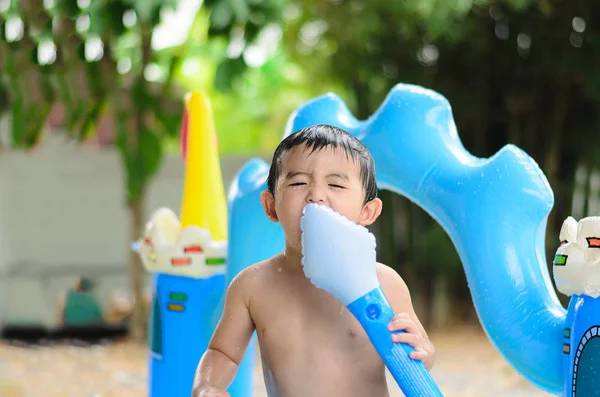 Asian kid playing in inflatable baby swimming pool on hot summer — Stock Photo, Image