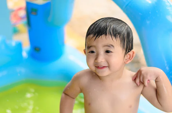 Niño asiático jugando en la piscina inflable del bebé en verano caliente — Foto de Stock