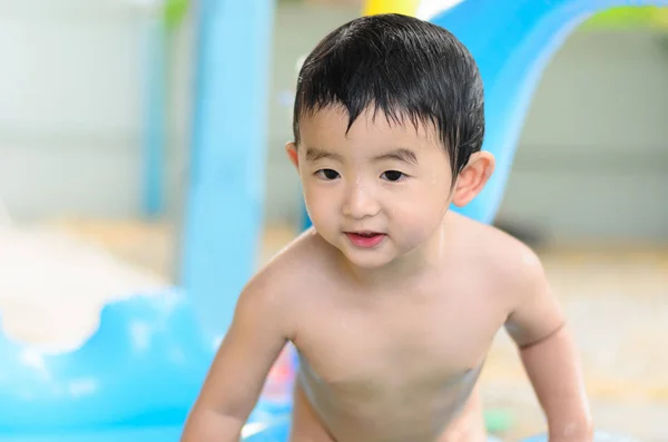 Asian kid playing in inflatable baby swimming pool on hot summer — Stock Photo, Image