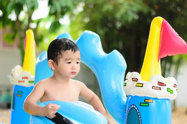 Niño asiático jugando en la piscina inflable del bebé en verano caliente — Foto de Stock