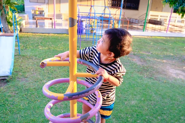 Active little child playing climbing spring metal at school yard — Stock Photo, Image