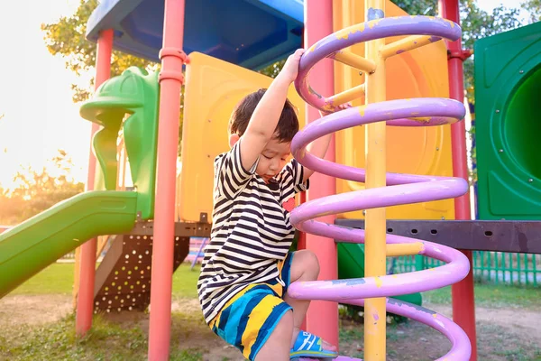 Aktiva litet barn spela klättring våren metall på skolgården — Stockfoto