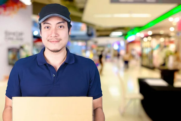 Asiático sorriso Entrega homem com caixa de papelão na mão pé em — Fotografia de Stock