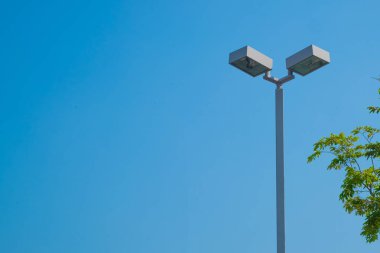 Mavi gökyüzü arka plan ve ağaç ile lamba sonrası Elektrik Sanayi